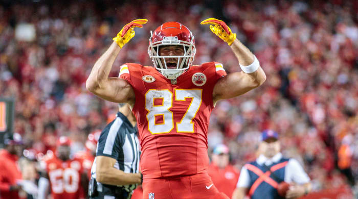 Travis Kelce raises his hands up above his heads in celebration